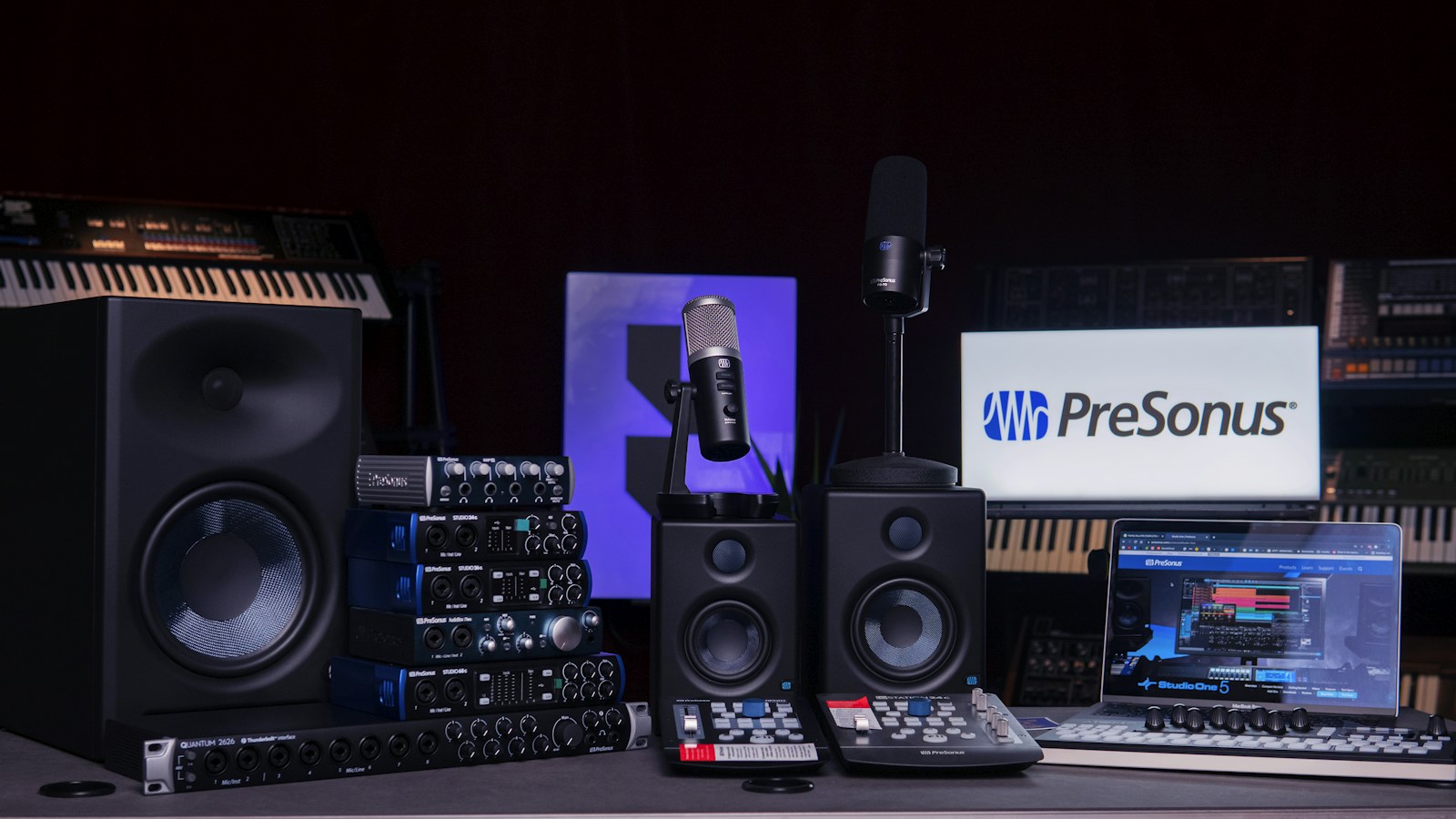 Audioarbeitsplatz mit Computer, Lautsprechern und Mikrofon.
